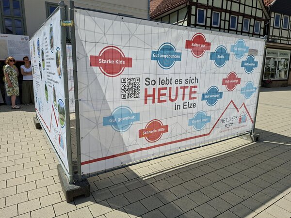 Vier Banner im Quadrat zeigen "So lebt es sich heute in Elze" - Hier zum Ausstellungsbeginn im Juni 2026 an der Hauptstra&szlig;e