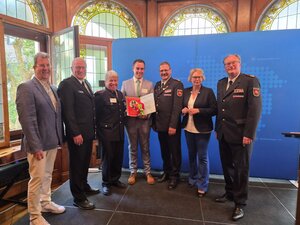 F&ouml;rderplakette "Partner der Feuerwehr" wurde &uuml;berreicht: B&uuml;rgermeister Wolfgang Schurmann, Vorsitzender des Kreisfeuerwehrverbandes Hildesheim Heiko Bartels, Stadtbrandmeister Oliver Kleiner, Gesch&auml;ftsf&uuml;hrer Yannik Mazarin, Pr&auml;sident des LFV Niedersachsen Olaf Kapke, Innenministerin Daniela Behrens, Vizepr&auml;sident des LFV f&uuml;r den Bezirk Hannover Karl-Heinz Mensing